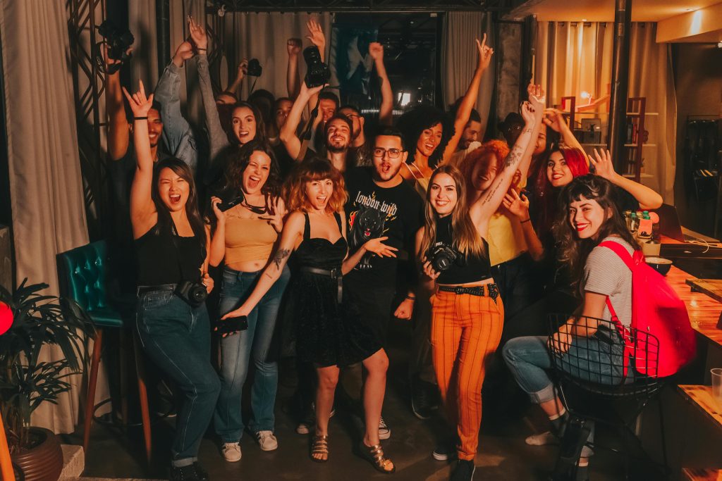 Un grupo de amigos celebrando alegremente en un evento, vitoreando y luciendo muy felices.